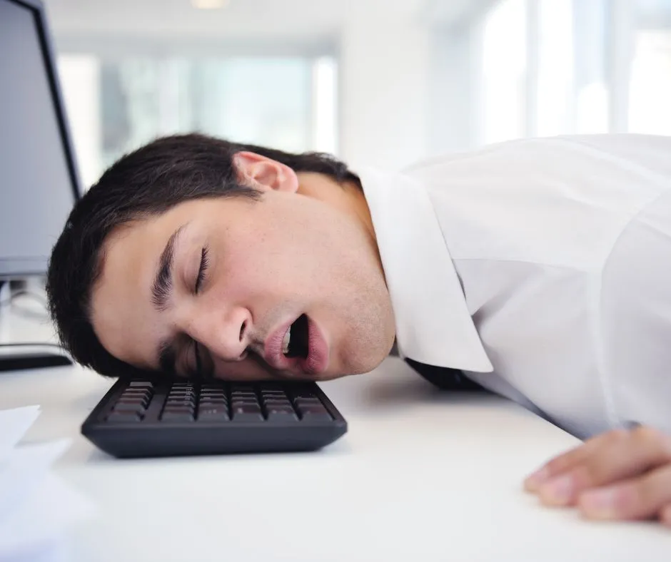 Person sleeping in office hours due to fatigue cause by magnesium deficiency